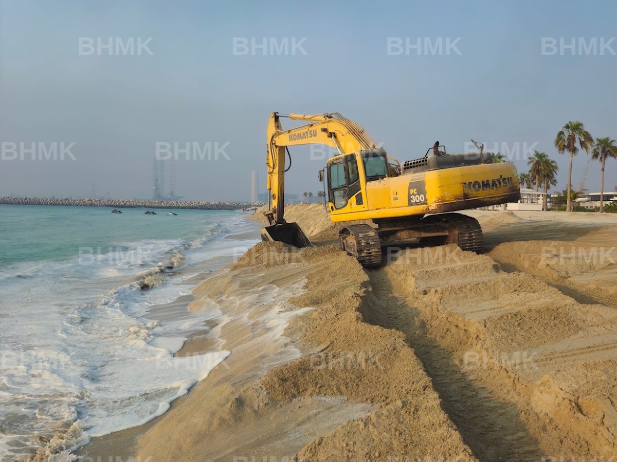 BHMK Komatsu PC300 excavator shaping the shoreline during beach nourishment in Dubai
