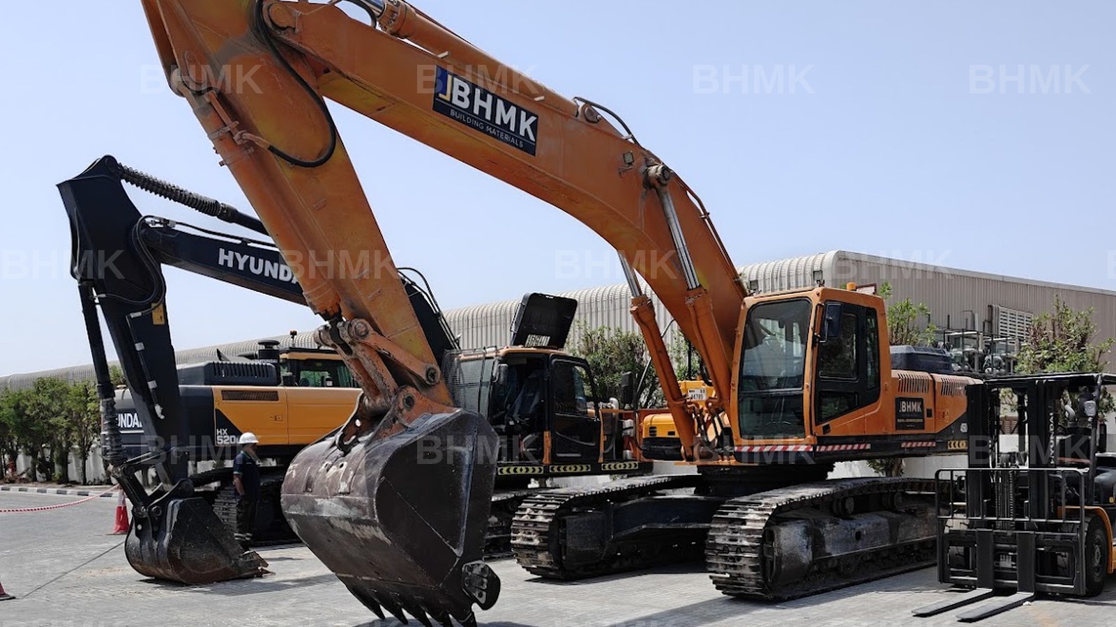 BHMK excavators, loader and forklift parked with an operator at the Dubai plant yard